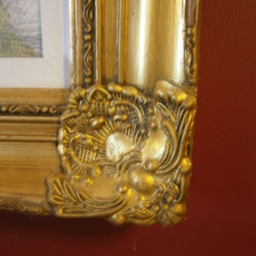 Gilt frame against rich red wall