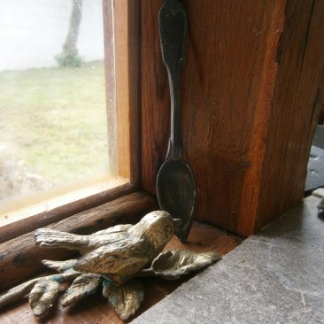 A little brass bird with a pewter spoon discovered in the old pig sty.